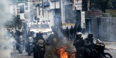 Un manifestante toma fuego durante disturbios en protesta en Venezuela