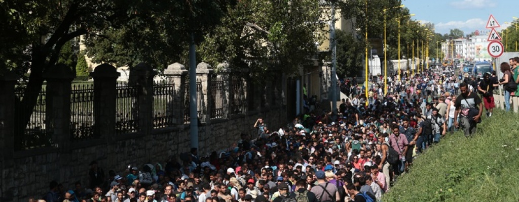 Migrantes marchan a pie desde Budapest hacia Austria buscando refugio